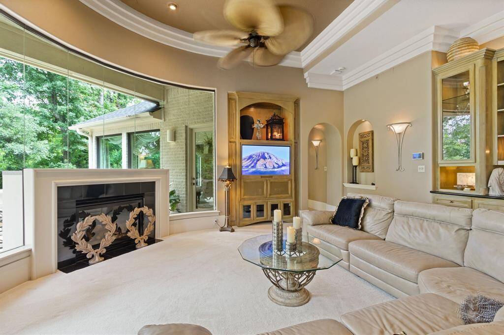 This elegant family room, located off the kitchen, features triple crown molding, built-ins, and a lighted art niche perfect for showcasing art.