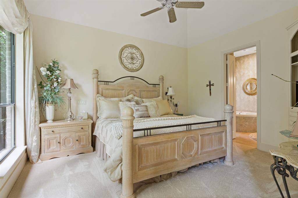 This private bathroom off of the third suite features a stylish vessel sink on a granite countertop, with ample cabinetry for storage. It has tiled floors and a shower with slate-like wall tiles, creating a modern and earthy ambiance. Soft lighting enhance the cozy, elegant feel.