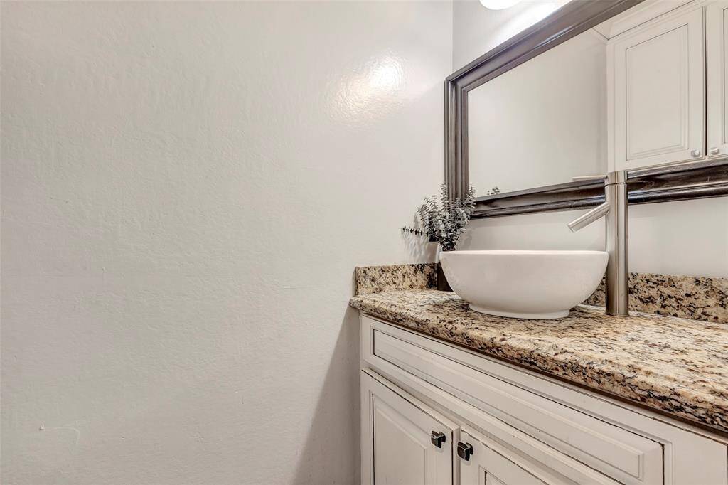 Half bathroom with vessel sink and granite countertop.