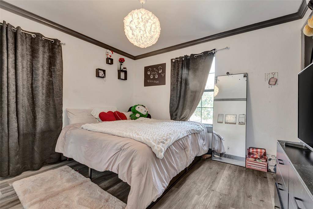 Inviting primary bedroom featuring elegant crown molding, and generous natural light from dual windows.