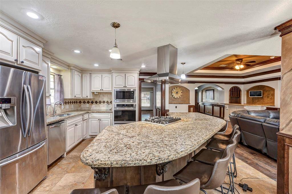 Open concept fully equipped kitchen with granite countertops and kitchen island.