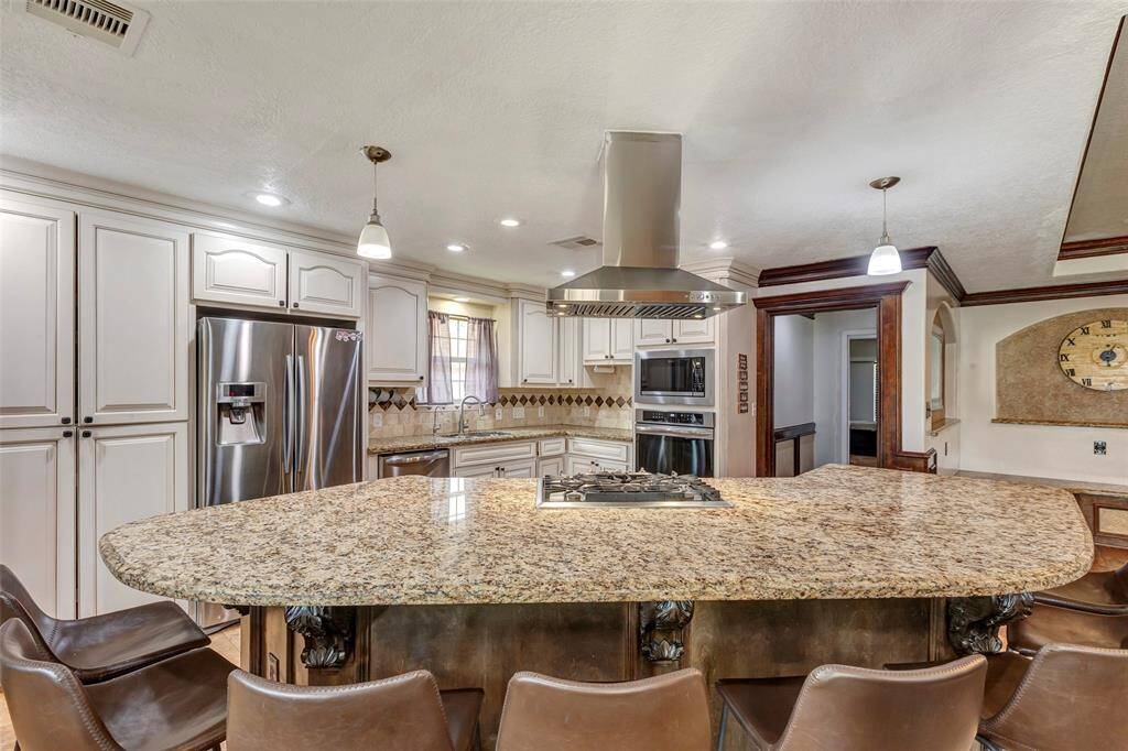 The kitchen features a large granite island with ample seating.