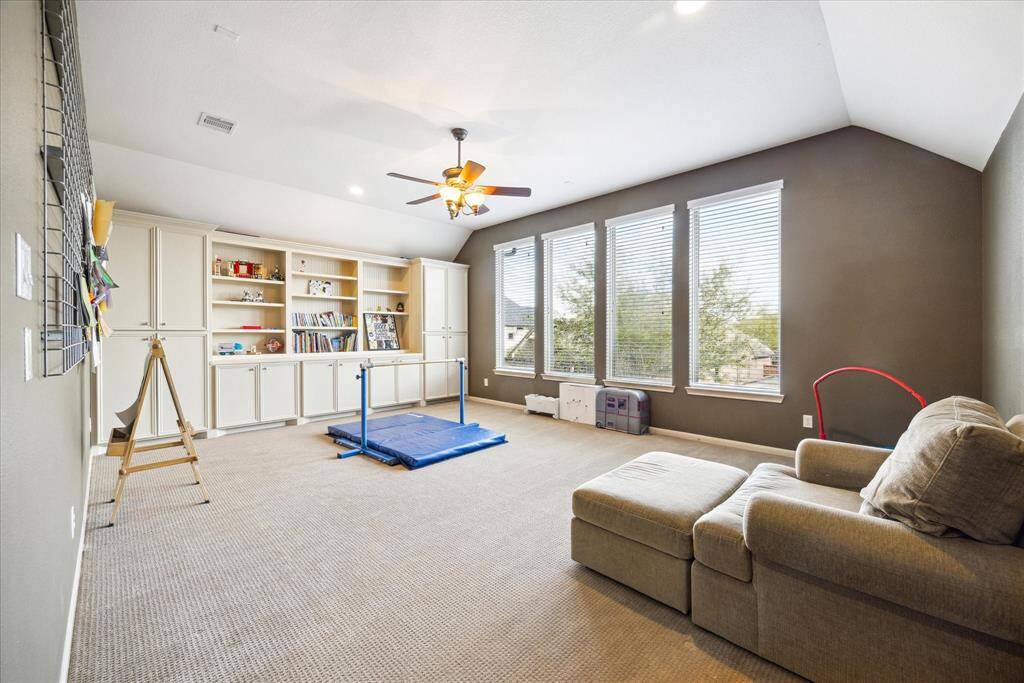 Oversized game room offers built-ins for storage of games and toys. Note the high ceilings and abundant natural light.