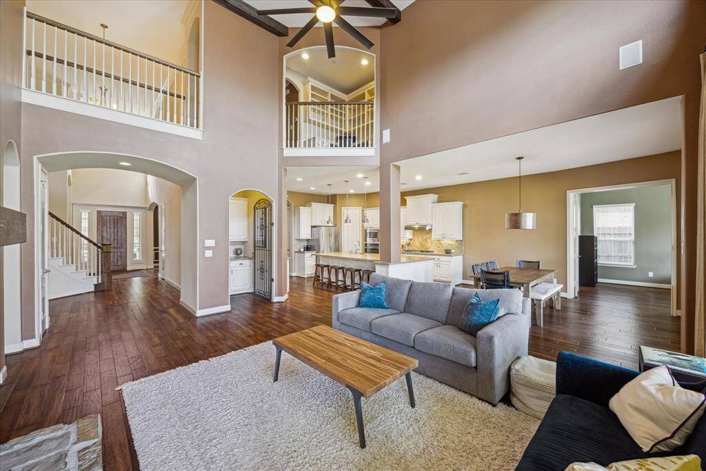 Another perspective of the expansive family room showing access to the entry, wine room, kitchen, and first floor flex space or guest bedroom.