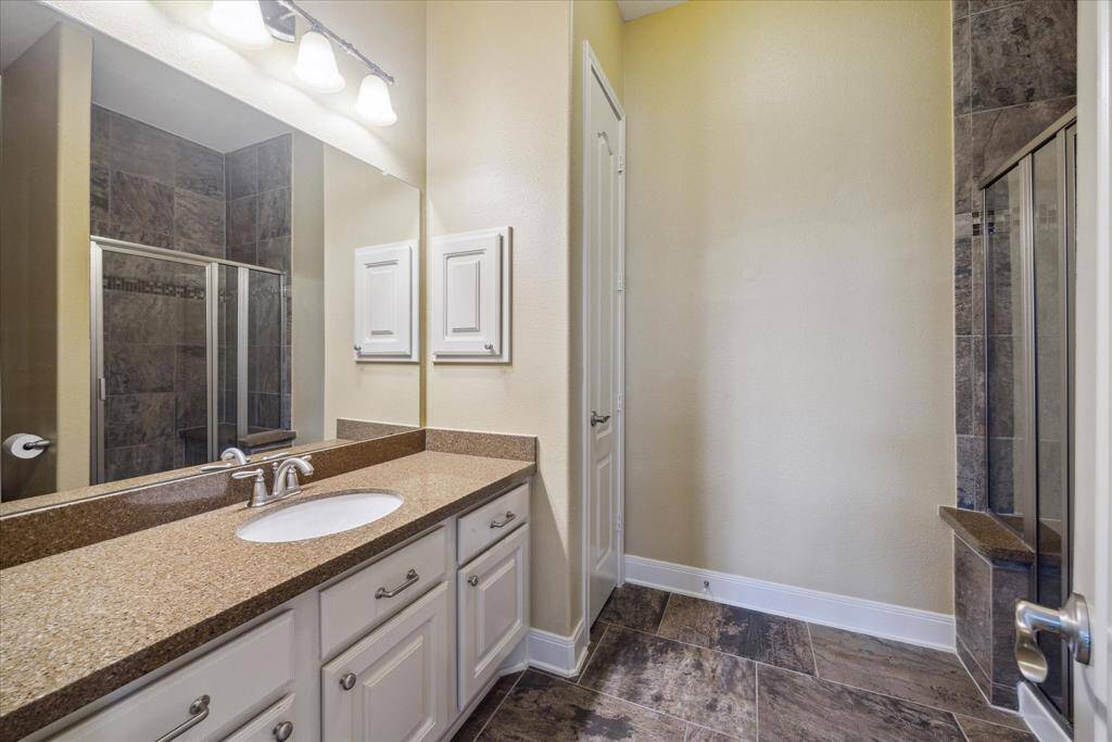 Guest bath with expansive countertop space, linen closet, and shower.