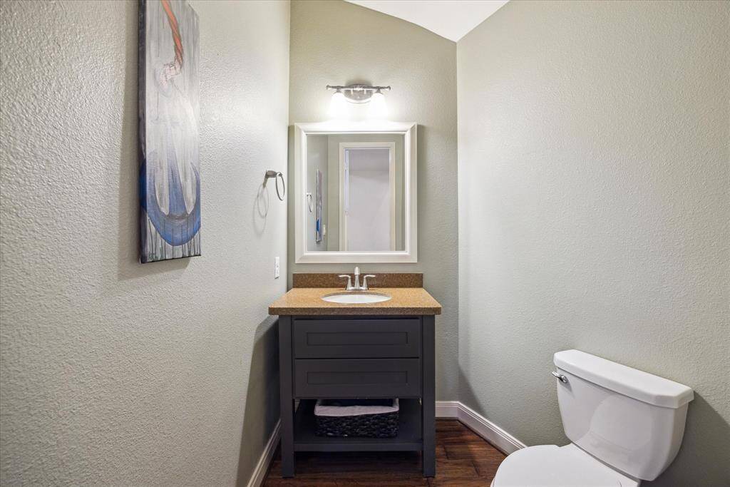 Powder bath is situated below the stairwell conveniently located off the entry near the family room.