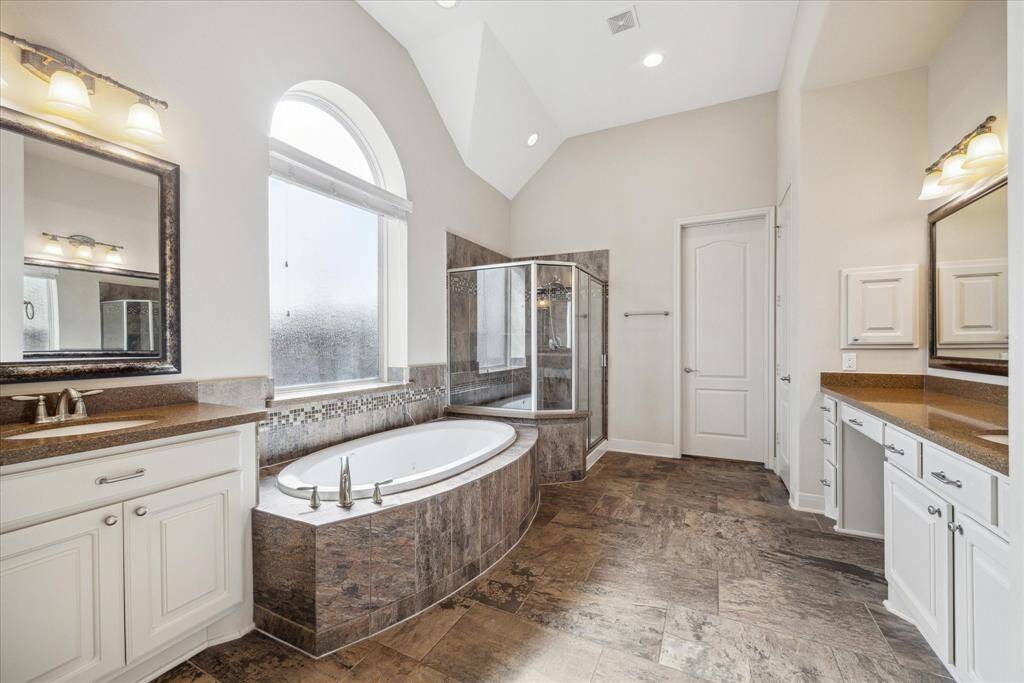 Primary bath is complete with tub and shower, separate sink areas with vanity, and private water closet.