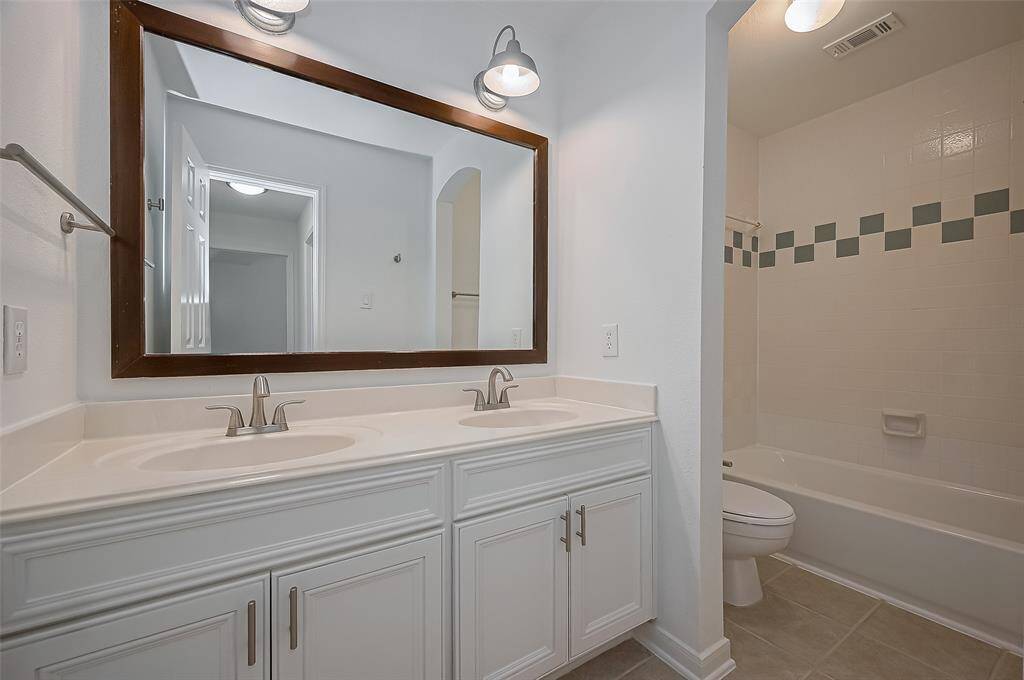 This shared bathroom, has double sinks, lots of storage and a tub/shower for convenience.