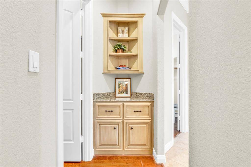Charming built-in display nook with granite countertop and upper shelves—ideal for showcasing art, or additional storage.