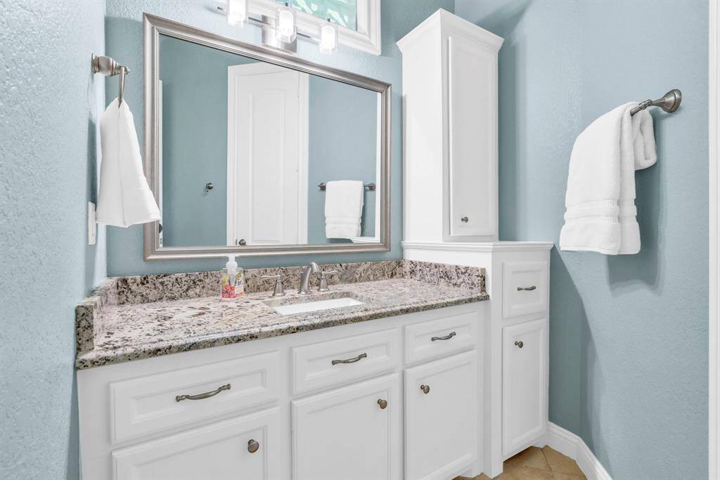 Second matching vanity in the Hollywood bath mirrors the first with its own sink, storage tower, and upgraded fixtures.