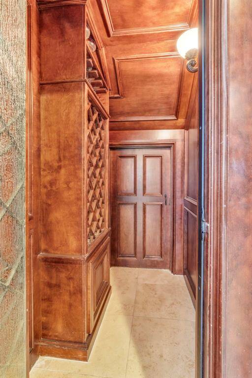 Wine grotto lined with rich millwork, lattice bottle storage, and additional storage behind—your personal tasting retreat just steps from the main entertaining spaces.