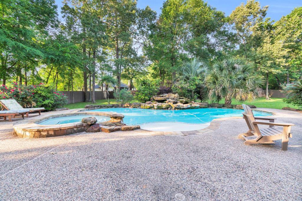 Sparkling free-form pool with elevated spa, flagstone coping, and tropical landscaping invites you to unwind in your very own private oasis.
