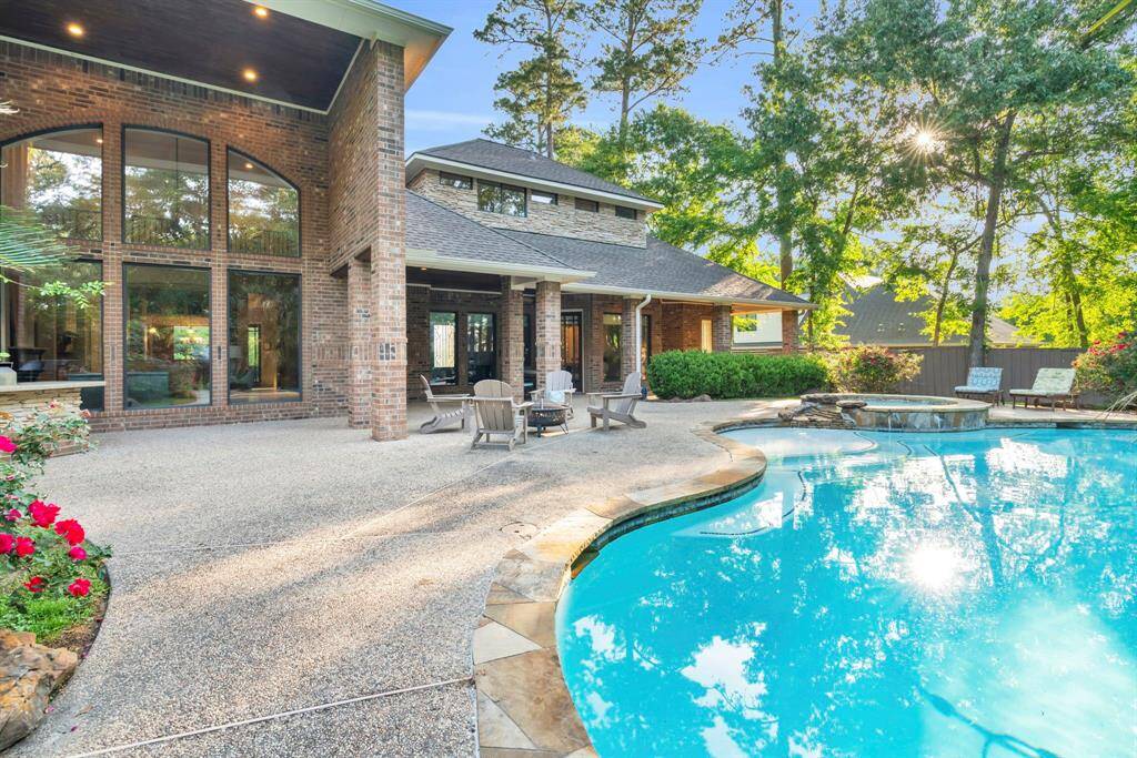 Expansive covered patio stretches the full width of the home, with pebble-finished floors. Just steps away, a dedicated pool bathroom—with full sink and handy storage closet—keeps wet feet out of the main house while ensuring towels and supplies are always within reach.