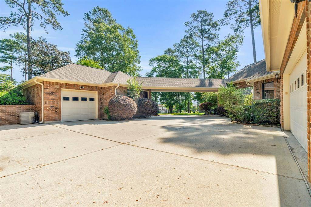 Expansive courtyard-style driveway with porte-cochère offers abundant open and covered parking with a welcoming entry, while a charming pathway guides guests toward the private casita.