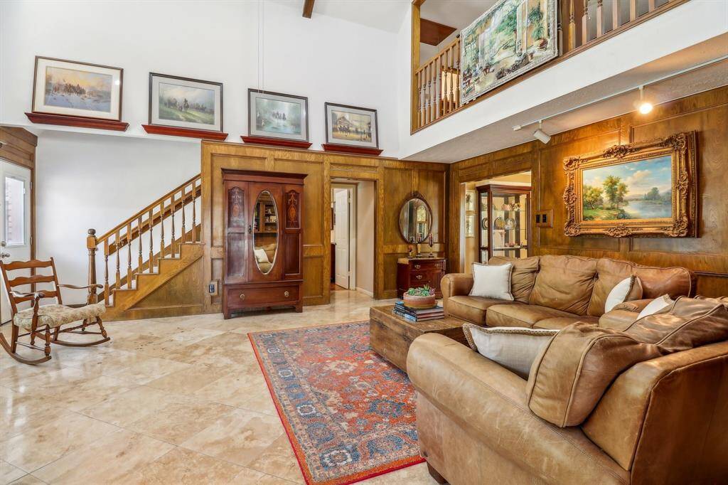 The doorway leads to the primary bedroom suite and the wide staircase leads upstairs to the game room, three more bedrooms, and 2 full baths.