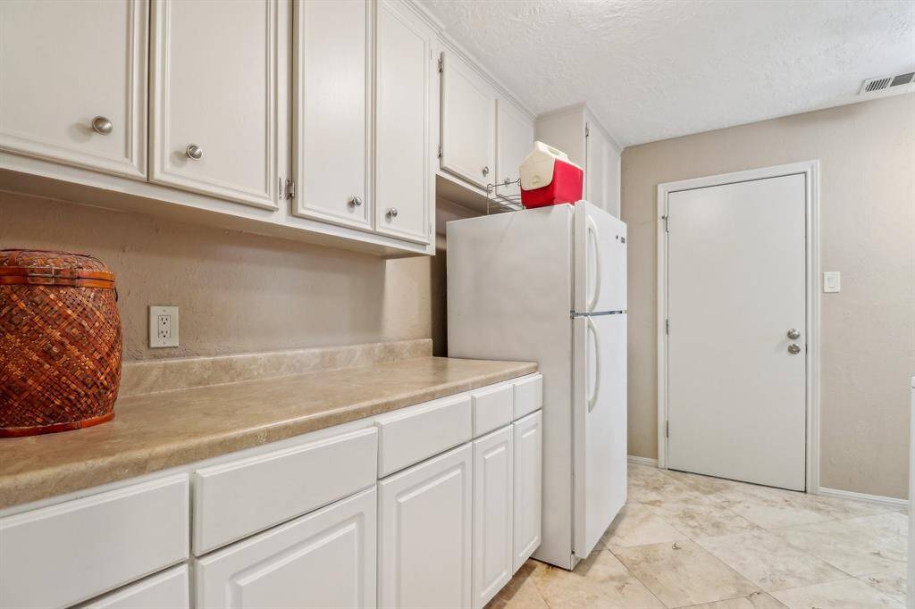 This laundry room also has additional cabinet and counter space plus an extra fridge that is included with the home.