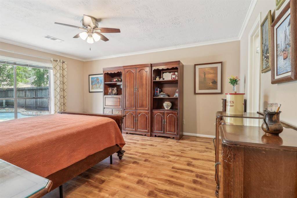 Huge primary suite with large windows overlooking the pool and attractive laminate flooring.
