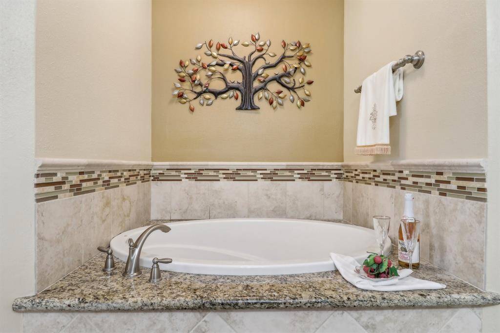 Relax in the deep soaking tub. Notice the granite surround has room to set your beverage, book, tablet, etc. A nice feature.