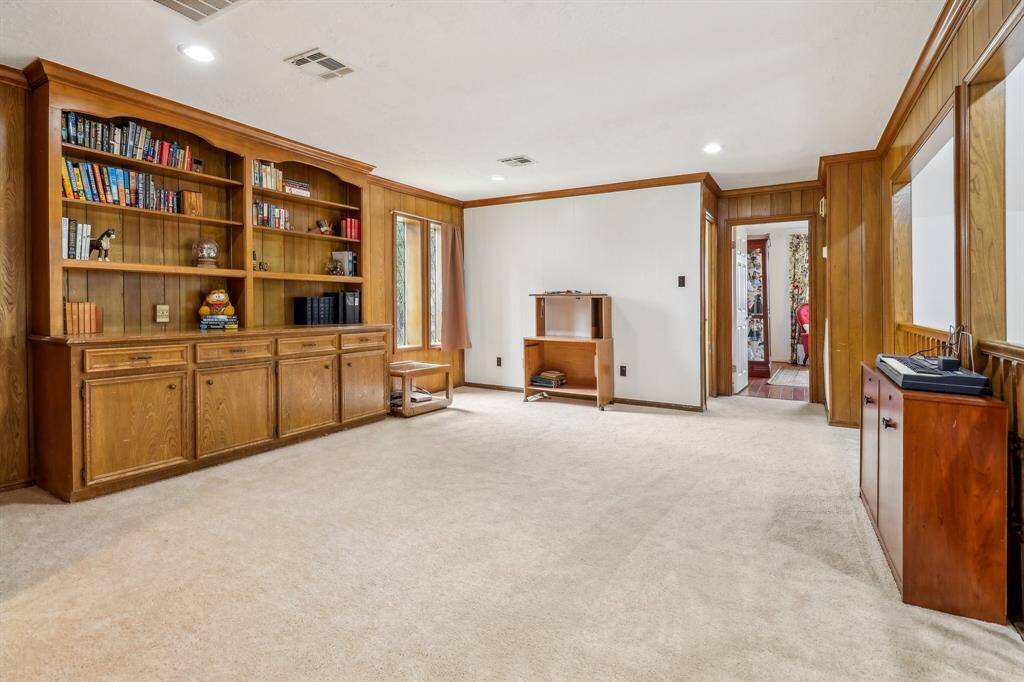 Upstairs game room looks down into living room and features new carpet and great built-ins for all the fun and games, hobbies, and electronics.