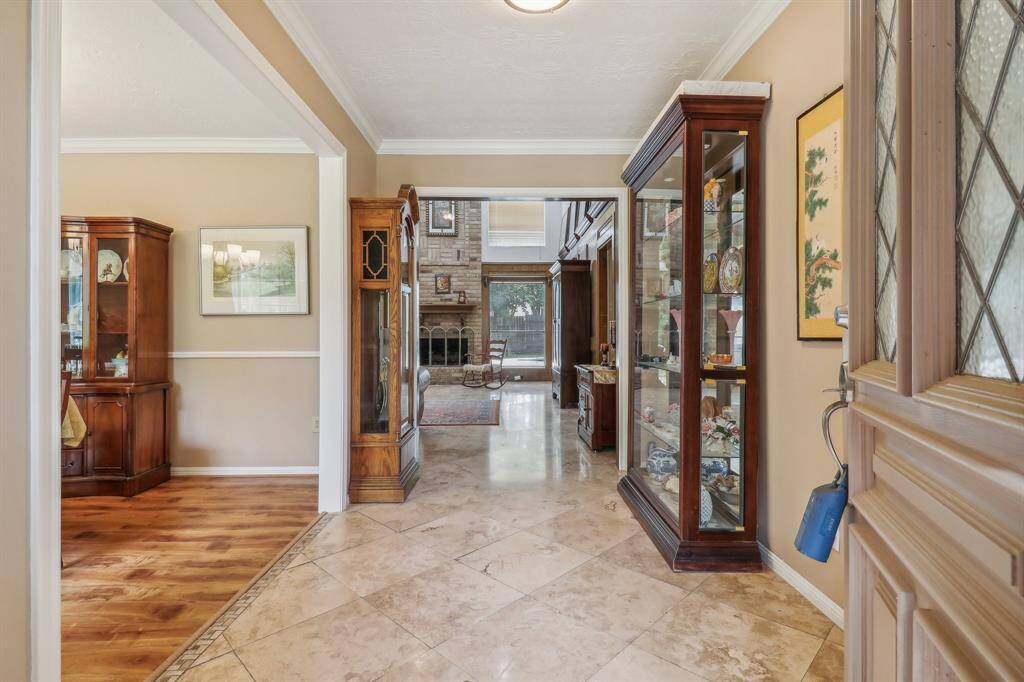 Open the front door and find an elegant formal entry hall with custom tile work. Notice the wide hall has room for side tables, display cabinets, benches, or any type of decor you like. Formal dining is just to the left.