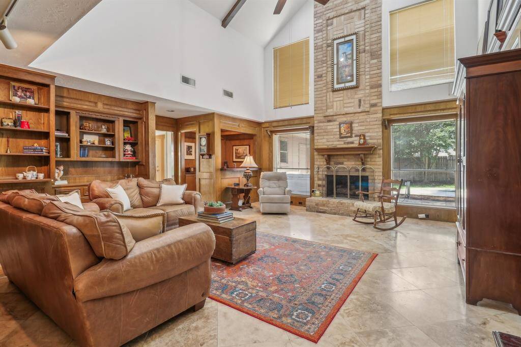 Come on through to the huge living room with high ceilings and a central fireplace that has gas logs but is also wood burning. Raised hearth and attractive wood mantle offer character and warmth to the room.