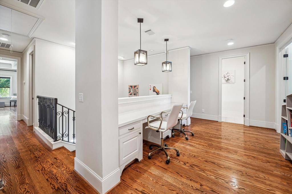 Thoughtfully designed built-in workstation located just off the stair landing, featuring dual desk areas with drawer storage, pendant lighting, and a sleek quartz surface. Perfect for homework, creative projects, or remote work, this versatile nook is seamlessly integrated into the upstairs layout while maintaining an open, airy feel thanks to wide hallways.