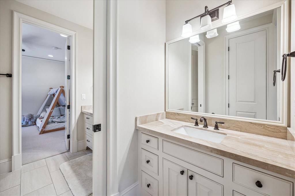 This alternate view highlights the thoughtful layout of the Jack-and-Jill bathroom, with dual entrances providing direct access from each bedroom. The split design ensures added privacy and ease of use for shared living.