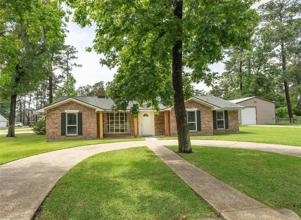 Charming single-story brick home with a welcoming front entrance, surrounded by lush greenery. Features a circular driveway and mature trees, providing ample shade and curb appeal. Perfect for those seeking a cozy, inviting space.