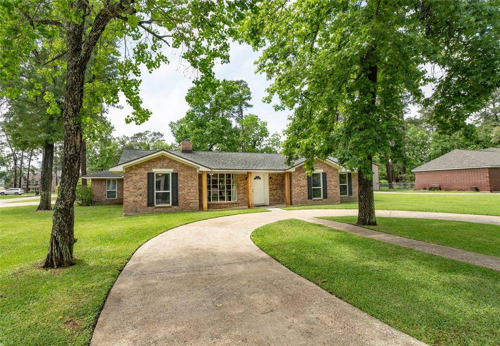 Beautiful curb appeal, with a welcoming front porch, surrounded by mature trees and a well-maintained lawn. Features a curved driveway and a quiet, green setting.