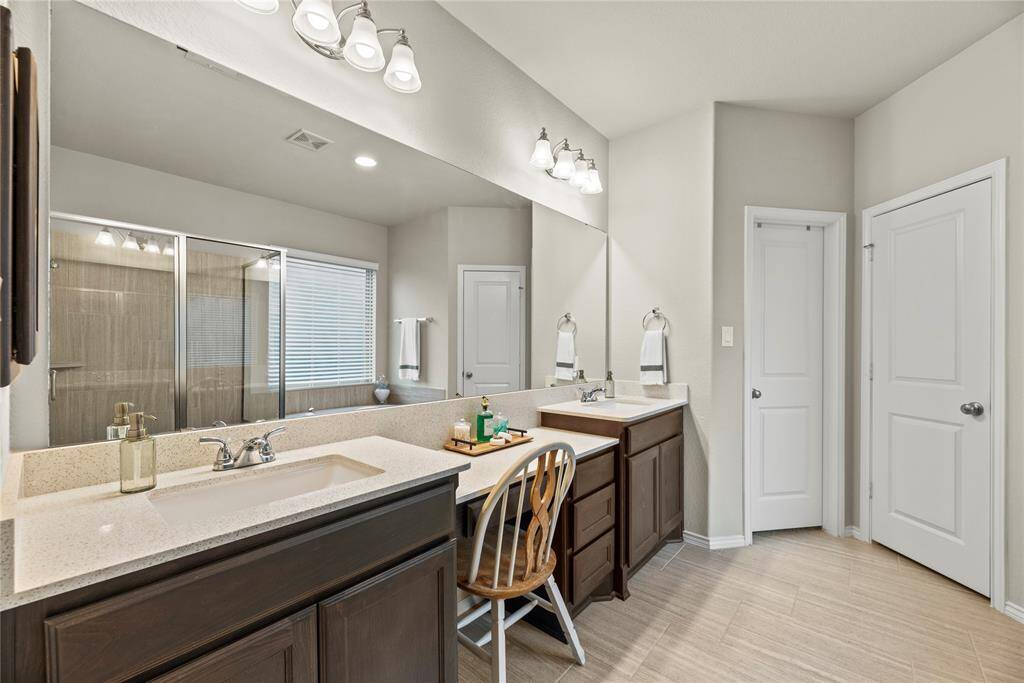 The primary bathroom is complete with a dual sink vanity, makeup counter, soaking tub, separate shower and walk-in closet.