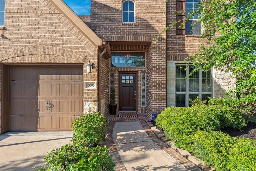 Lovely brick and stone elevation with lush landscaping.