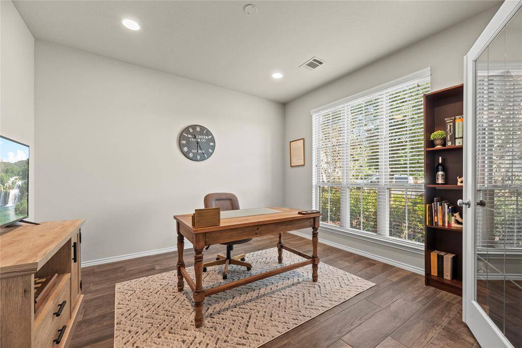 The home office is just off the front entry and offers wood-look tile flooring and French doors for privacy.