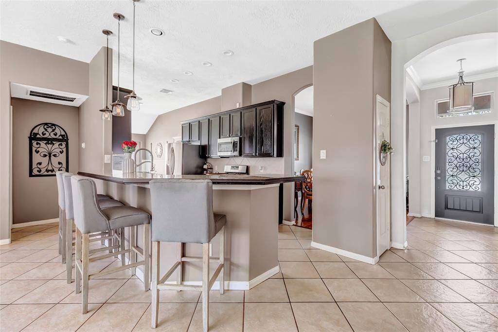 This home features a modern kitchen with a breakfast bar, pendant lighting & tons of storage space.