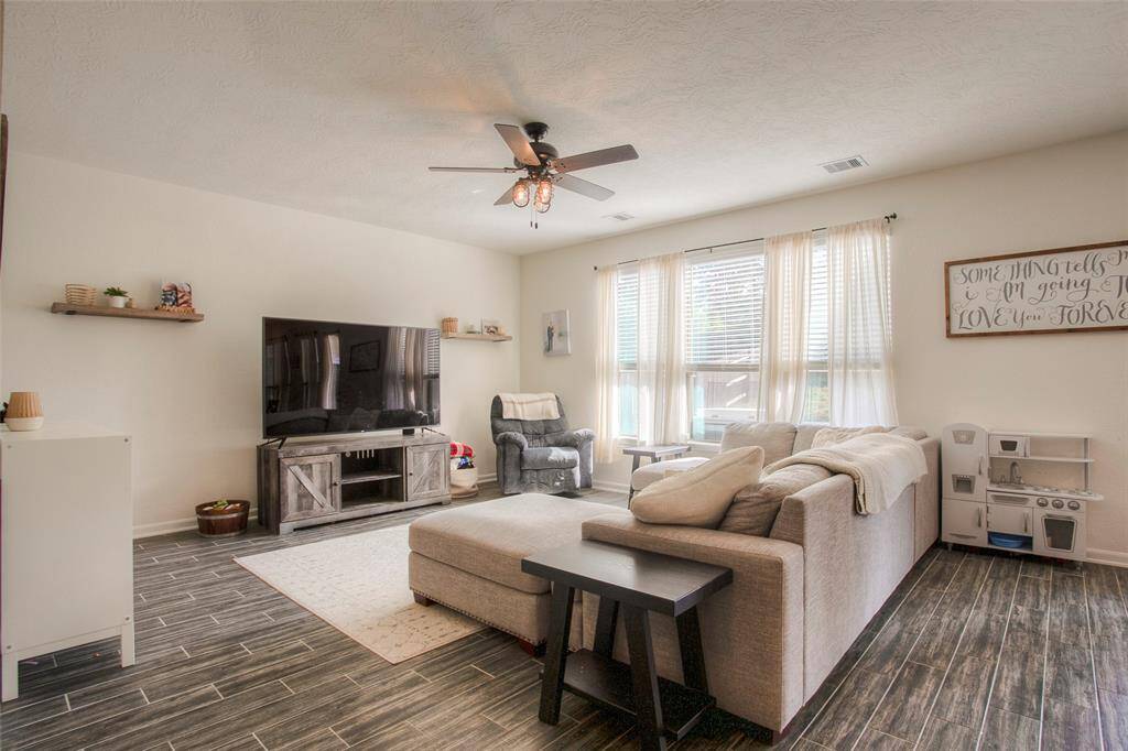 An open-concept living/dining/kitchen area is filled with natural light...