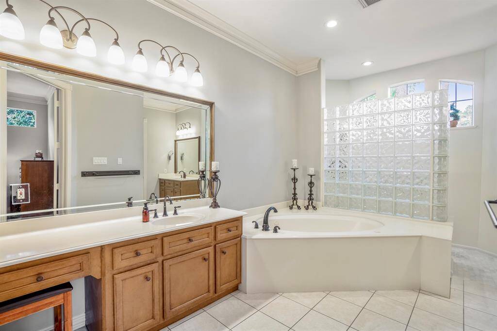 The primary suite features dual vanities, a soaking tub, & seperate walk-in shower