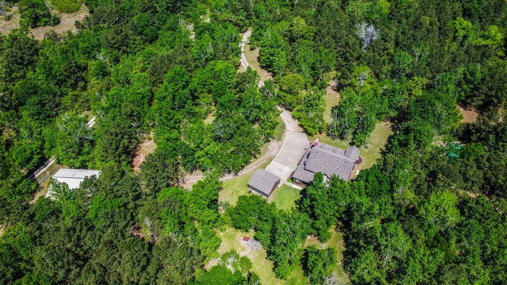 Aerial view of home & garage with the storage building and pool.