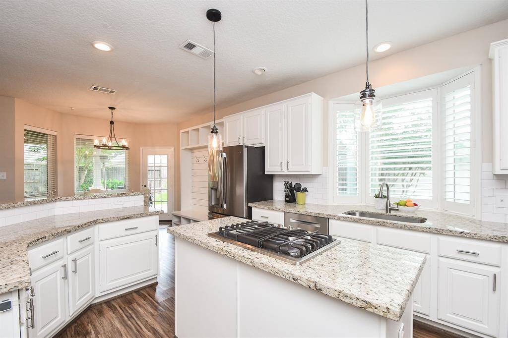 As you prepare snacks at your island under the  modern pendant lights, you can watch your family in the living and breakfast room with this open floor plan. Note the miles of cabinets and drawers to store away all your pots and pans and kitchen gadgets.