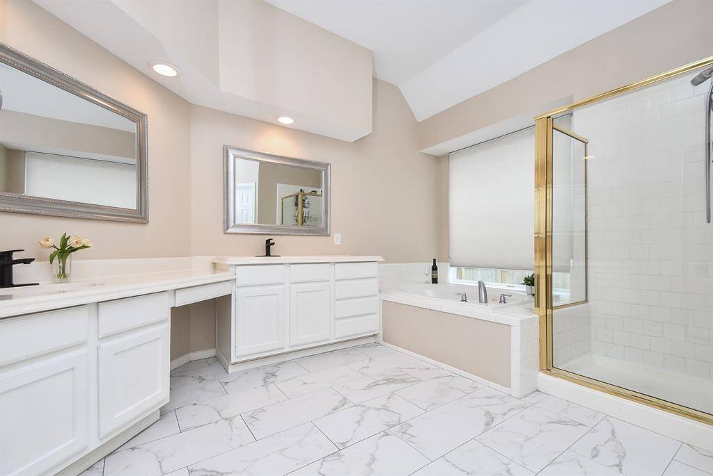 Your oasis of a primary bathroom - measuring 10' x 12'! Your primary bathroom offers beautiful tile flooring, double sinks and separate vanity areas with miles of counterspace,  tile-surround shower and jacuzzi tub where you can relax at the end of a long day.
