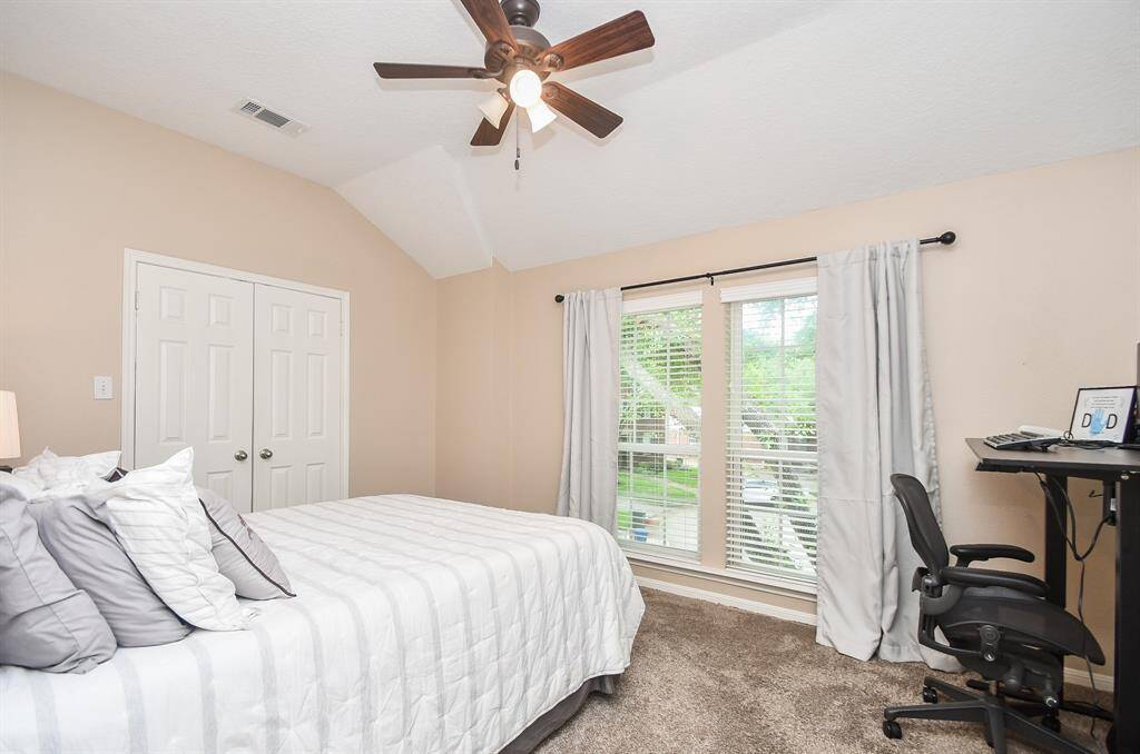 To the right, bedroom #2 measures 11' x 14' and is complete with huge windows, sizable closet, ceiling fan, and cozy carpet. Plenty of space for your teen to have their own workspace.  All bedrooms and closets are so generously-sized in this home!