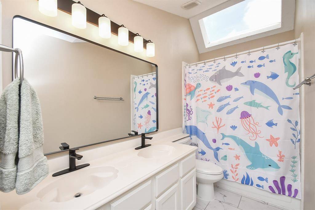 Your secondary bathroom, conveniently located between all bedrooms, measures 5' x 11' and is perfect for siblings to share! It is updated with new double faucets, light fixture and mirror with plenty of counter and cabinet space for toiletries and towels, and shower/tub combo.