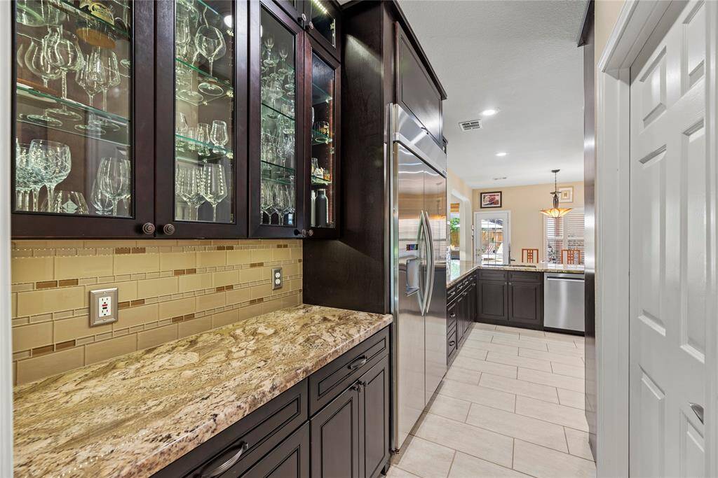 Alternate view of the kitchen showcasing additional countertop space, ample cabinetry for storage, and a built-in dishwasher for added convenience. The door to the right is the laundry room.