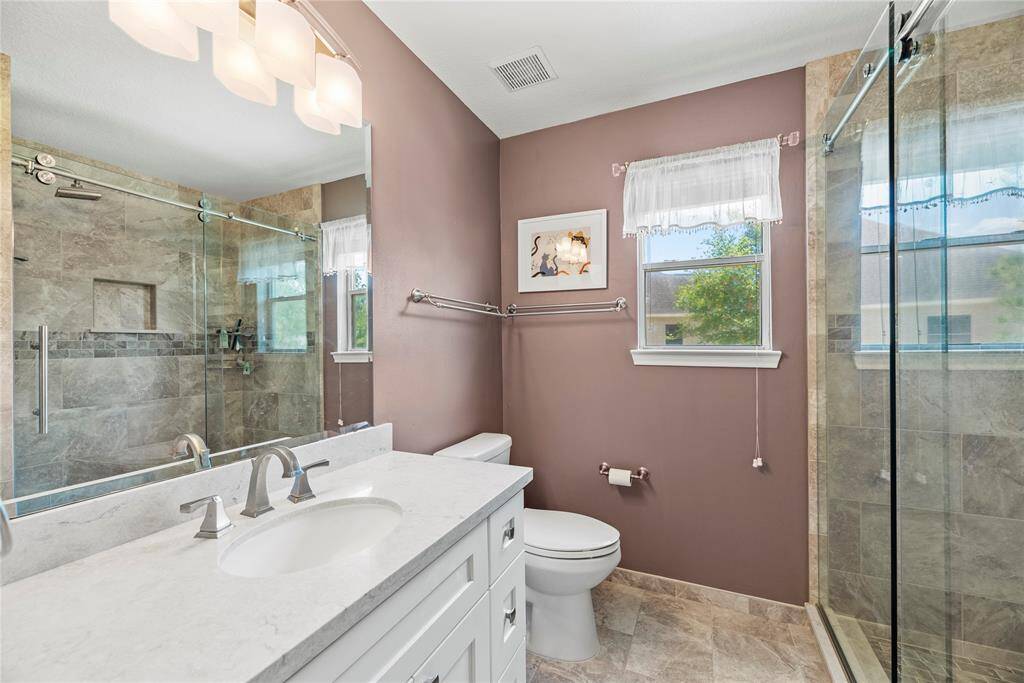 The second-floor bathroom in the hallway features a countertop with sink, a large vanity for added storage, and a shower for convenience.
