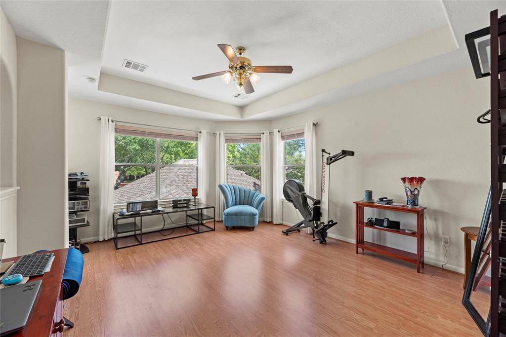 The second-floor flex room boasts hardwood flooring, a ceiling fan, and large corner windows offering a beautiful view of the backyard. This versatile space is open to the hallway, making it ideal for various uses.