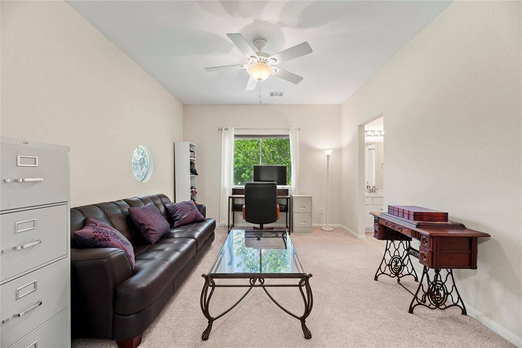 The third bedroom on the second floor features carpet flooring, a ceiling fan, and its own private bathroom with a walk-in closet, offering both comfort and convenience.