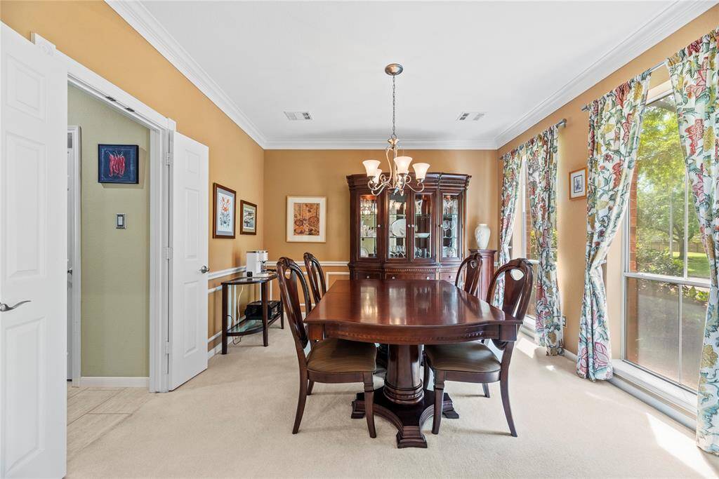 Dining room measuring 12.6 x 12.6 features carpet flooring and a large window with views of the front of the home.