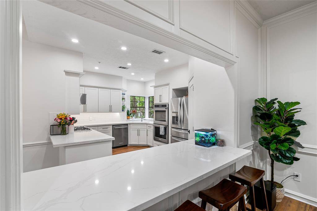 A stylish breakfast bar overlooks the chef’s kitchen, creating a seamless space for casual dining and conversation.