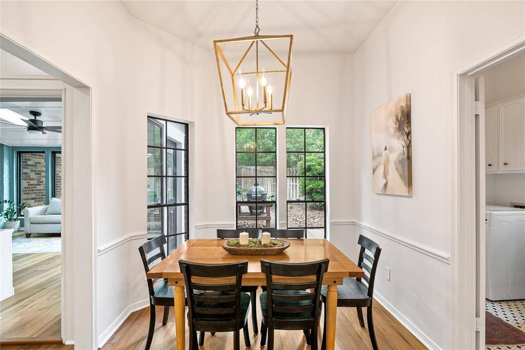 Another angle of the dining area reveals picturesque views of the backyard and direct access to the sunroom, blending indoor comfort with outdoor charm.