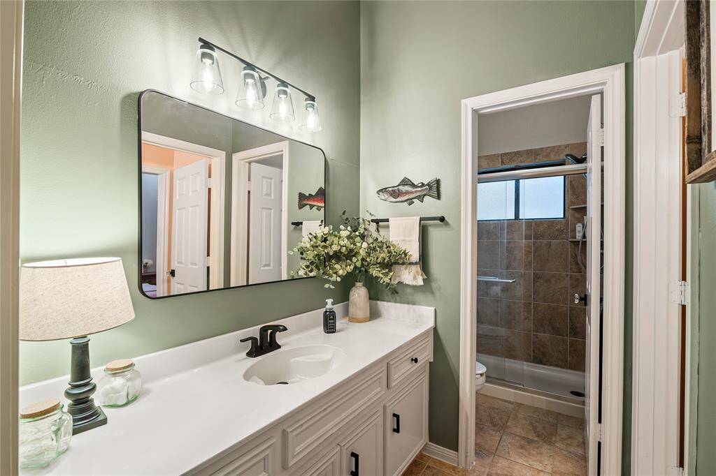 The second full bath is beautifully appointed with a shower and sleek quartz countertops, offering both style and functionality.