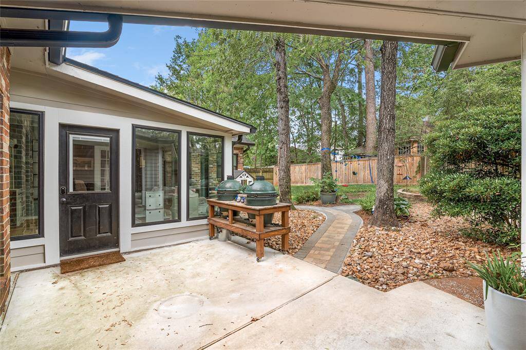 The backyard features a charming sitting area that overlooks the beautifully landscaped yard, providing the perfect spot to relax and enjoy the outdoors.