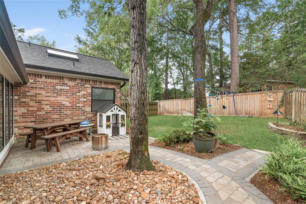 A second cozy sitting area in the backyard offers additional space to unwind, surrounded by the beauty of the landscaped yard.